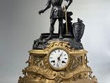 a statue of a man standing on top of a clock