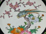 a plate with a bird and flowers on it