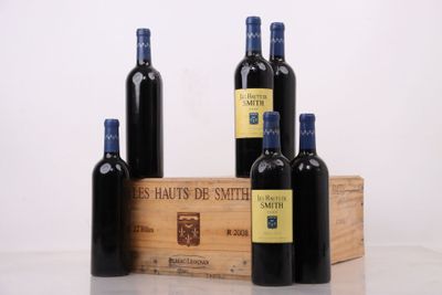 trois bouteilles de vin sont posées à côté d'une caisse en bois sur une table