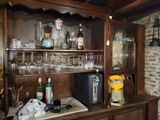 a wooden cabinet with wine glasses on top of it