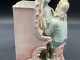 a figurine of a man and a woman sitting on a bench