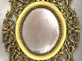 a mirror that is on the wall with a gold frame