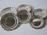 six assiettes plaquées argent, avec des bords argentés sur un fond blanc
