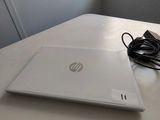 a white laptop sitting on a table next to a window