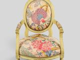 a chair with a floral upholstered back and a gold frame