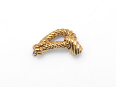 un gros plan d'une bague en fil d'or sur une surface blanche