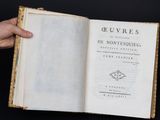 quelqu'un tient un livre à la main près d'une pile de livres