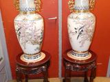 deux vases posés sur un petit tabouret devant un mur rouge