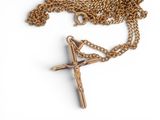 a cross on a gold chain on a white background