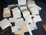 a pile of mail sitting on top of a table next to a cell phone
