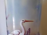 un vase en verre avec un tableau posé sur une table
