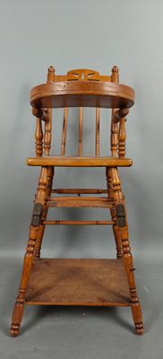 une vieille chaise haute en bois avec une assise en bois posée sur une étagère