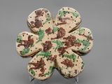 a cookie shaped like a flower with green and brown sprinkles on it