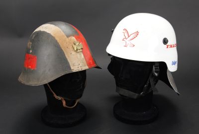 deux casques ornés de motifs rouges et blancs, posés sur une surface noire