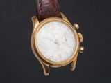 un gros plan d'une montre-bracelet en or avec un bracelet en cuir marron