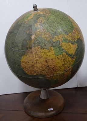 un globe vert et jaune posé sur un socle en bois