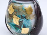 a glass vase with gold and blue designs on it