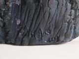a black stone with writing on it sitting on a white surface