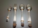 four silver spoons and two silver spoons on a table