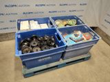 deux bacs bleus remplis d'objets divers, posés sur une palette