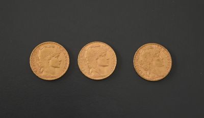 three different types of gold coins on a black surface