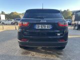 the rear end of a black jeep parked in a parking lot