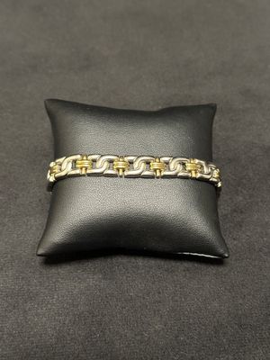 a close up of a gold bracelet on a black pillow