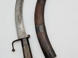 two knives are laying on top of each other on a white surface