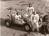 des astronautes posant devant un véhicule à la surface de la Lune