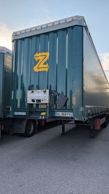 two semi trucks parked next to each other in a parking lot