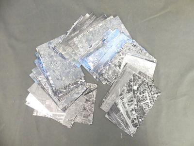 many pieces of silver foil sitting on a table
