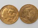 a close up of two gold coins on a white surface
