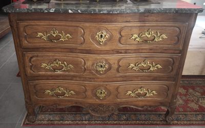 a wooden dresser with a marble top on a rug