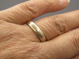 la main d'une personne à laquelle est passée une bague en or
