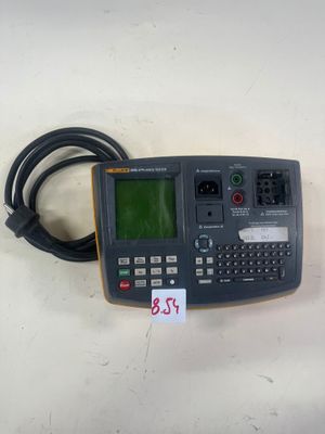 un gros plan d'une calculatrice posée sur une table, avec un câble