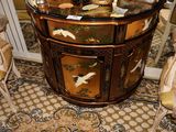 une petite table avec un plateau en verre orné d'un motif d'oiseau