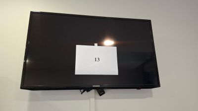 a flat screen tv mounted on the wall with a sign on it