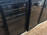 two glass door refrigerators sitting on top of a hard wood floor