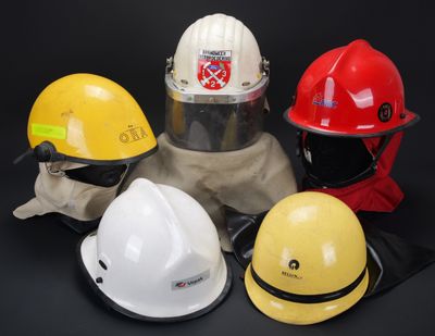 Plusieurs types de casques de chantier sont alignés sur un fond noir