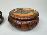 a wooden box with a painting on it next to a tea cup