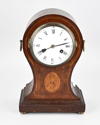 a small wooden clock with roman numerals on the face