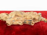 a statue of a woman laying down on a red blanket