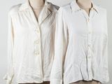 two mannequins with white shirts on them on a wooden stand