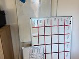 a white board with red lines on it next to a whiteboard