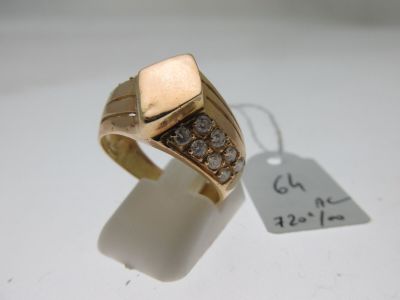 une image d'une bague en or avec des diamants sur une surface blanche