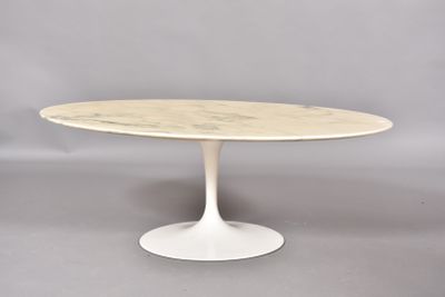 une table ovale en marbre avec un piètement blanc sur fond gris