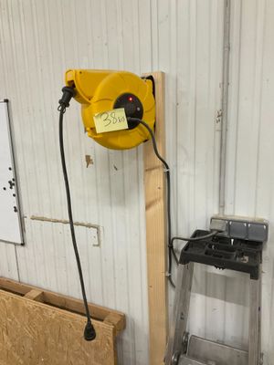 un tuyau jaune fixé au mur à côté d'une échelle