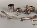 a lot of silver spoons and other silverware on a table