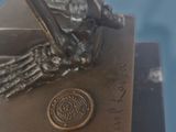a bronze statue of a bird on a book