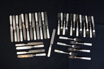 de nombreuses fourchettes et couteaux disposés sur une table